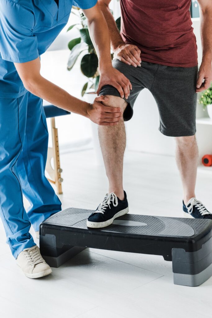 cropped view of doctor touching knee of mature pat 2026 03 12 22 38 02 utc